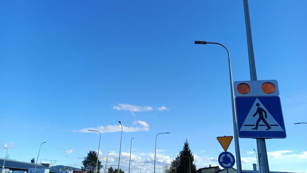Zapalone lampy ostrzegawcze aktywnego przejścia dla pieszych przy rondzie